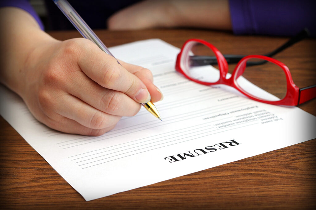 filling resume on wooden table, close-up