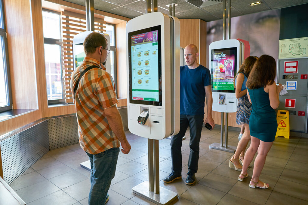 MOSCOW, RUSSIA - CIRCA AUGUST, 2018: men use self ordering kiosk in McDonald's